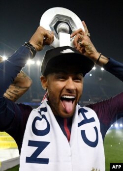 L'attaquant brésilien Neymar tient son trophée après avoir remporté le titre de champion de France L1 à la fin du match de football L1 français PSG vs Rennes, le 12 mai 2018, au Parc des Princes à Paris.