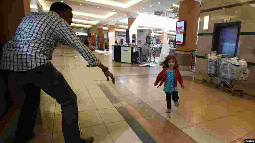 A child runs to safety as armed police hunt gunmen who went on a shooting spree at Westgate shopping center in Nairobi, Kenya, Sep. 21, 2013. The gunmen stormed a shopping mall, killing at least 20 people in what the government said could be a terrorist attack.