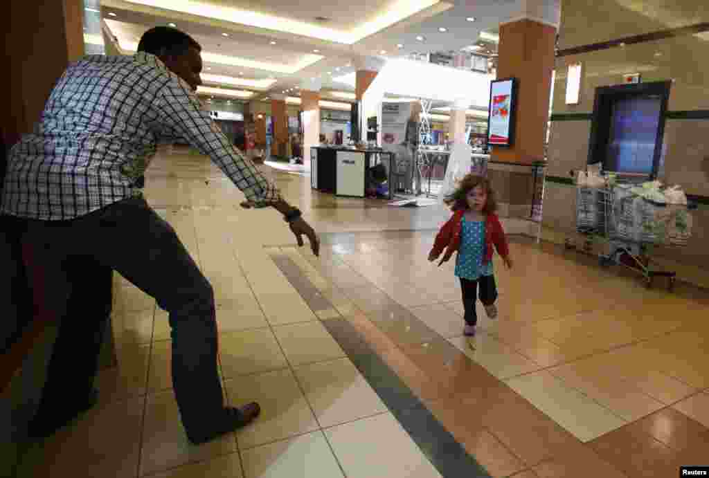 A child runs to safety as armed police hunt gunmen who went on a shooting spree at Westgate shopping center in Nairobi, Kenya, Sep. 21, 2013. The gunmen stormed a shopping mall, killing at least 20 people in what the government said could be a terrorist attack.