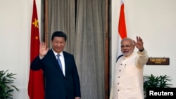 印度总理莫迪和中国国家主席习近平在新德里海德拉巴宫会晤前对媒体挥手致意。（2014年9月18日）