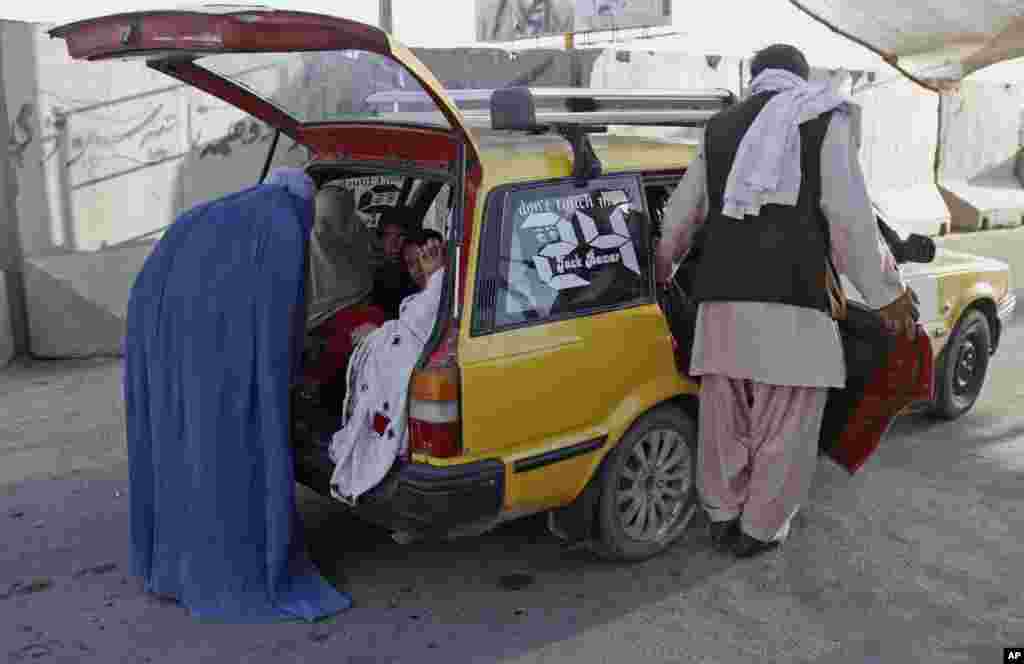 A female police officer, in blue burqa, searches female passengers at a checkpoint in Kandahar, south of Kabul, Afghanistan, June 13, 2014.&nbsp;