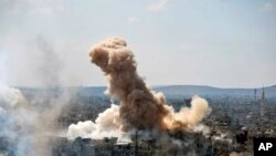 In this photo released by the Syrian official news agency SANA, smoke rises after Syrian government airstrikes and shelling hit in Hajar al-Aswad neighborhood held by Islamic State militants, southern Damascus, April 22, 2018.