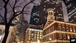 Faneuil Hall, right, is seen at night in Boston. Faneuil Hall is one of the historic sites on Boston's Freedom Trail.