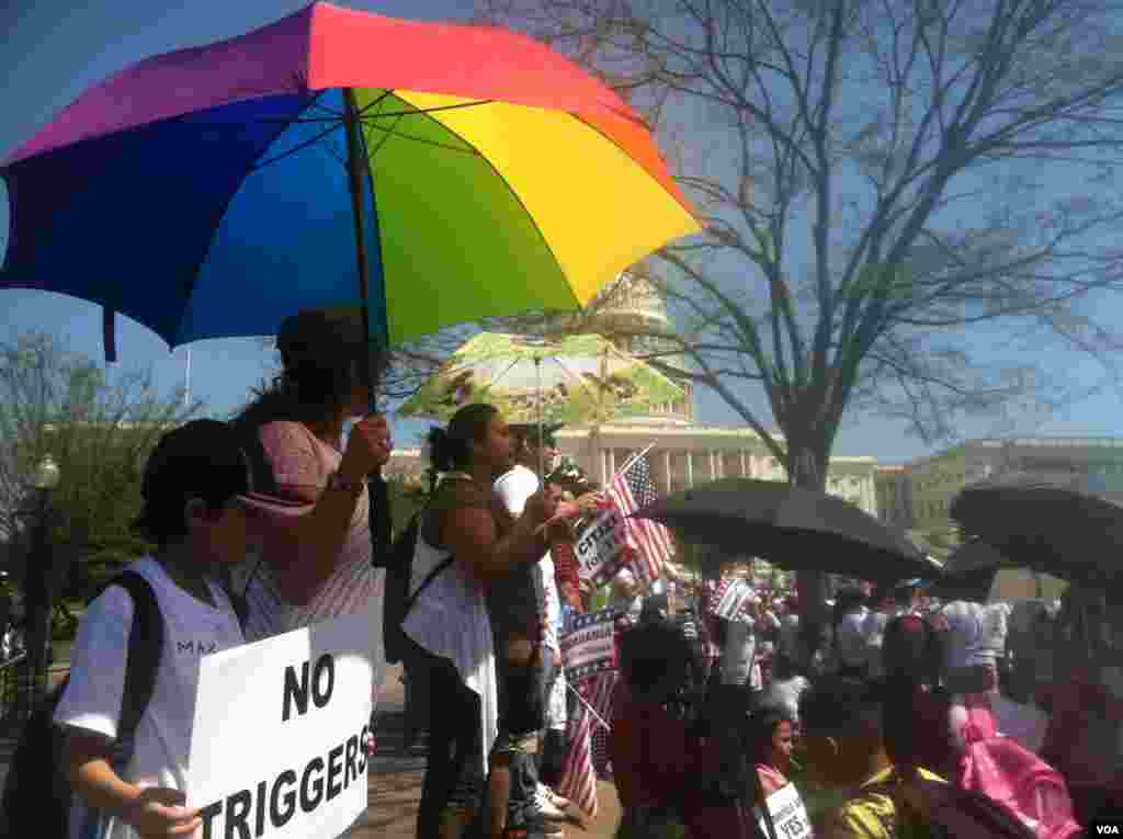 Immigration activists take refuge from the sun under umbrellas while rallying for Congress to create a pathway to citizenship for the undocumented immigrants in the U.S. Washington, DC, Wednesday, April 10, 2013. (Photo by Kate Woodsome)