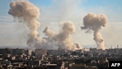 Smoke rises from buildings following bombardment on the village of Mesraba in the rebel-held besieged eastern Ghouta region on the outskirts of the capital Damascus, Feb. 19, 2018.