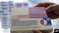 A clinic staff shows boxes of Infanrix and Pentaxim vaccines for infants at a children's clinic in Hong Kong, Tuesday, July 24, 2018, as they see a rise in the number of mainland parents bringing their children to Hong Kong for vaccinations following the