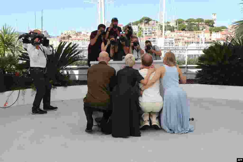 (From L) Russian actors Yuri Kolokolnikov, Chulpan Khamatova, Ivan Dorn and Yuliya Peresild hide behind the podium during a photocall for the film &quot;Petrov&#39;s Flu&quot; at the 74th edition of the Cannes Film Festival in Cannes, France.