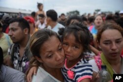 Migrants bound for the U.S.-Mexico border wait on a bridge that stretches over the Suchiate River, connecting Guatemala and Mexico, in Tecun Uman, Guatemala, Oct. 19, 2018.