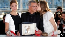 Director Abdellatif Kechiche, center, actors Lea Seydoux, left, and Adele Exarchopoulos pose with the Palme d'Or award for the film La Vie D'Adele after an awards ceremony at the 66th international film festival, in Cannes, southern France, Sunday, May 26