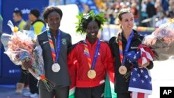 Mary Keitany, asal Kenya, tengah menjadi pelari pertama yang mencapai garis finish disusul oleh Sally Kipyego, asal Kenya, kiri, dan juara tiga Molly Huddle, asal AS, berpose di garis finish New York City Marathon 2016 (6/11). (foto: AP Photo/Seth Wenig)