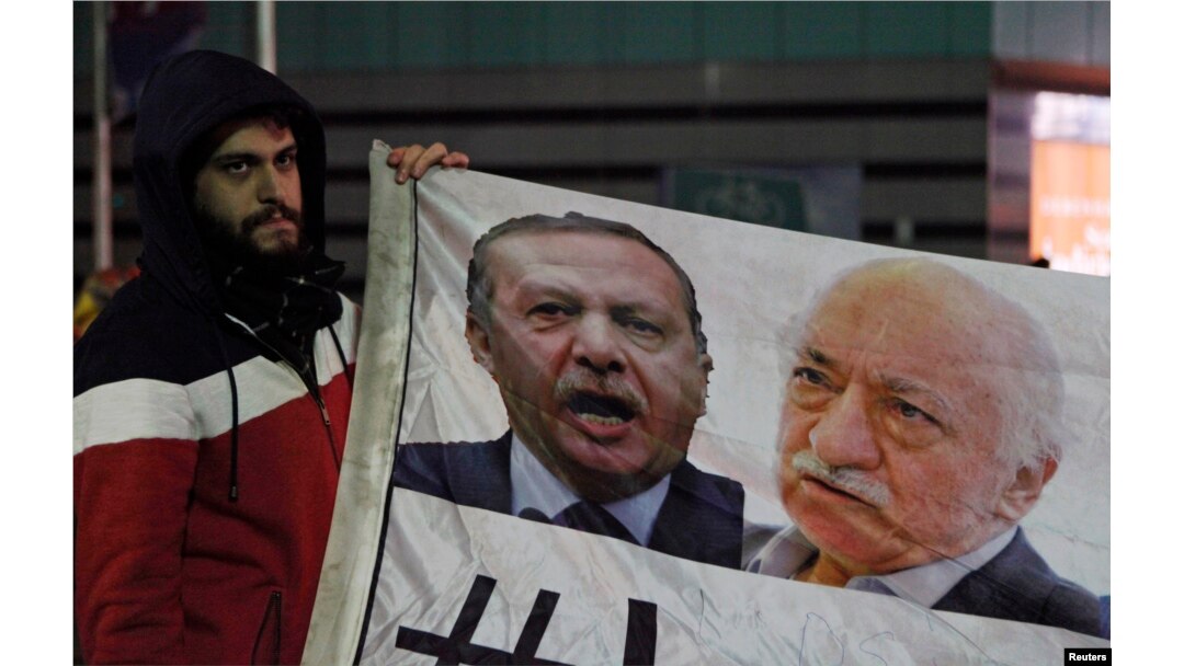 FILE - Demonstrator holds pictures of Turkey's Prime Minister Tayyip Erdogan and Turkish cleric Fethullah Gulen (R), during a protest against Turkey's ruling AK Party (AKP), demanding the resignation of Erdogan, in Istanbul Dec. 30, 2013.
