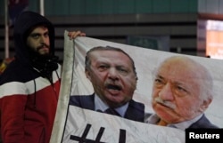 FILE - Demonstrator holds pictures of Turkey's Prime Minister Tayyip Erdogan and Turkish cleric Fethullah Gulen (R), during a protest against Turkey's ruling AK Party (AKP), demanding the resignation of Erdogan, in Istanbul Dec. 30, 2013.