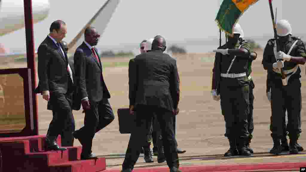 Le président français François Hollande, à gauche, et son homologue guinéen Alpha Condé passent en revue la garde d&#39;honneur, à Conakry, en Guinée, vendredi 28 novembre 2014.
