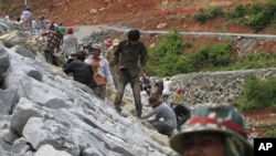 Local workers adjust stones at a dam construction site by China National Heavy Machinery Corporation on the Tatay River in Koh Kong province, some 210 kilometers (130 miles) west of Phnom Penh.