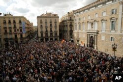 Miles de personas protestan afuera del palacio presidencial en la plaza Sant Jaume, en Barcelona, a favor de los exfuncionarios regionales destituidos por el gobierno de Madrid, que el jueves se presentaban en corte. Nov. 2, 2017.