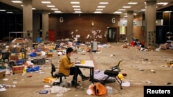 A journalist works on his laptop amid items left behind by protestors in Hong Kong Polytechnic University (PolyU) in Hong Kong, China, November 26, 2019. 