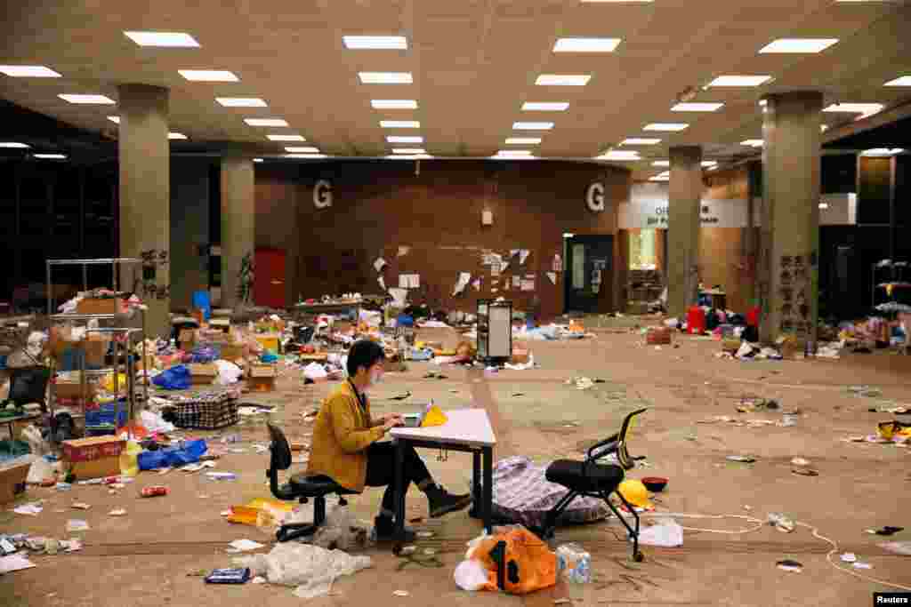 A journalist works on his laptop in a room where items left behind by protesters in Hong Kong Polytechnic University (PolyU), Nov. 26, 2019.