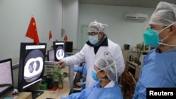 2020年2月2日，湖北省武漢市新冠病毒爆發後，醫務人員在武漢大學中南醫院檢查一名患者的CT掃描圖像。