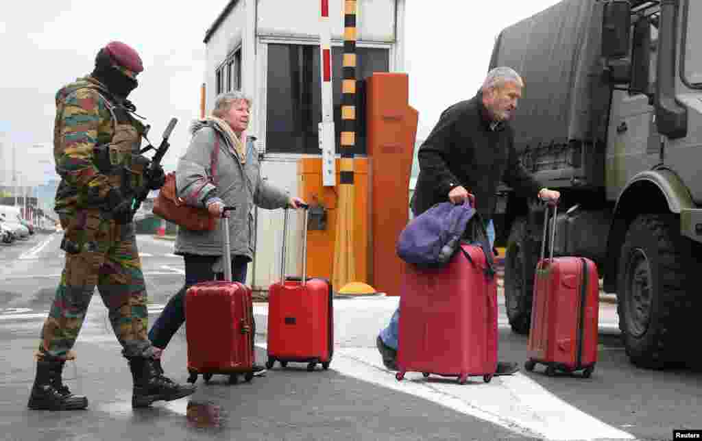 A Belgian soldier accompanies passengers at Brussels' Zaventem airport following Tuesday's bomb attacks in Brussels, March 23, 2016.