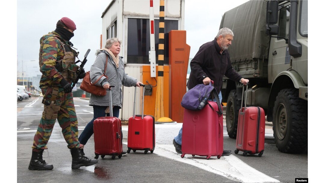 A Belgian soldier accompanies passengers at Brussels' Zaventem airport following Tuesday's bomb attacks in Brussels, March 23, 2016.