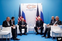 FILE - President Donald Trump meets with Russian President Vladimir Putin at the G-20 Summit in Hamburg, July 7, 2017. Russian Foreign Minister Sergey Lavrov is at left, then-Secretary of State Rex Tillerson is at right.