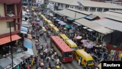 FILE - In this photo taken June 20, 2016, pedestrians shop at a market in Lagos, Nigeria.