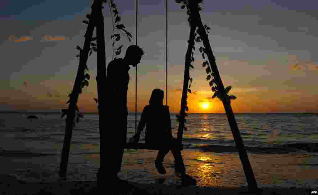 Dua muda-mudi Aceh menikmati matahari terbenam di pantai Lhok Nga, Aceh.