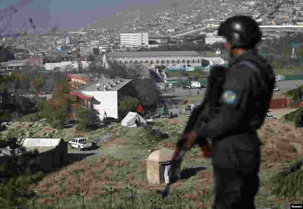 A police officer keeps watch at a vantage point overlooking the Loya Jirga tent in Kabul, Nov. 21, 2013.