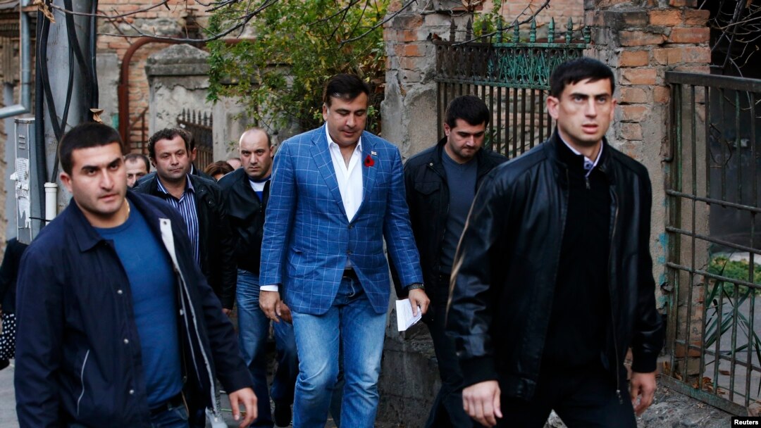 Georgia's outgoing President Mikheil Saakashvili (C) is seen heading to a polling station in Tbilisi October 27, 2013.