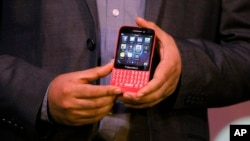 FILE - A BlackBerry official displays a BlackBerry Q5 smartphone during its launch.