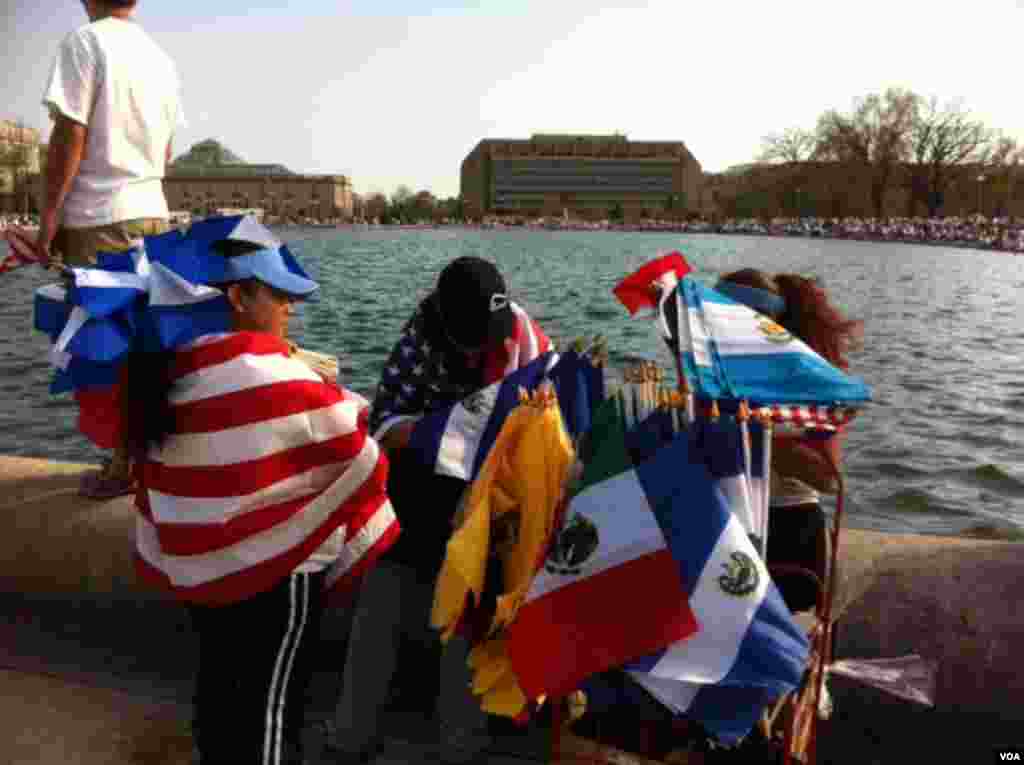 A flag vendor wraps herself in the American flag while selling the national colors of Colombia, Mexico, El Salvador and Guatemala. (Photo by Carolyn Presutti.)