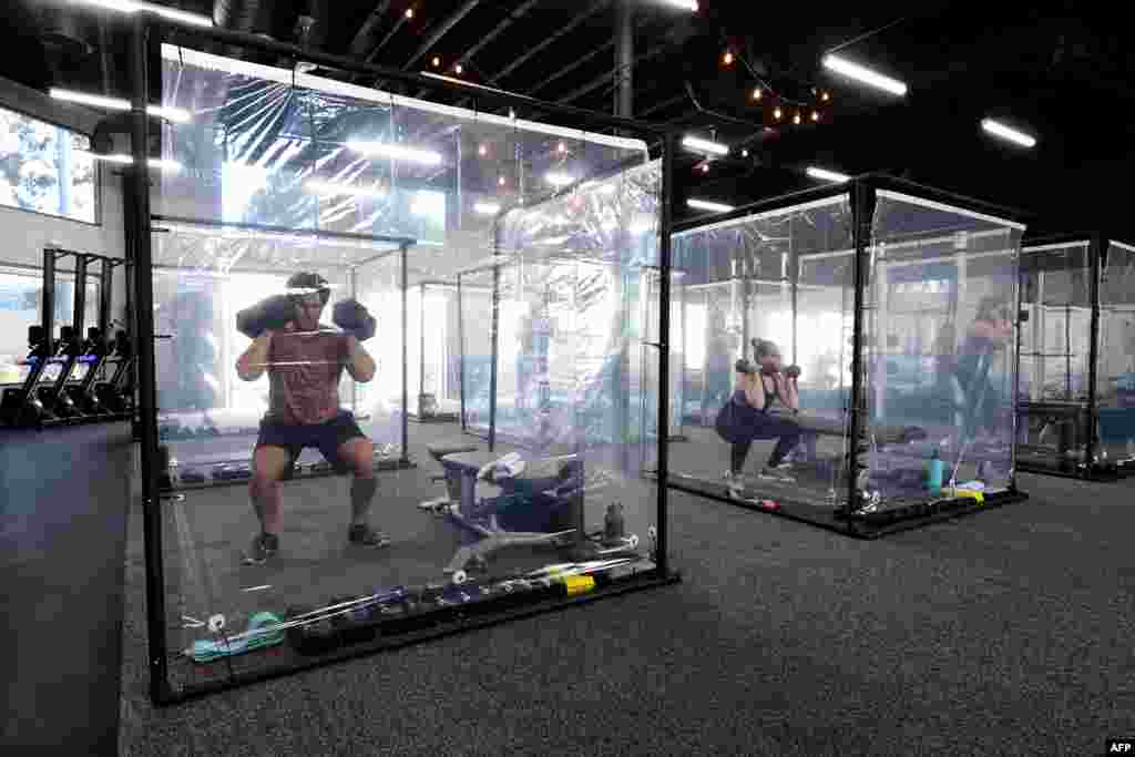 People exercisein their workout pods while observing social distancing at Inspire South Bay Fitness, June 15, 2020, in Redondo Beach, as the gym reopens under California&#39;s coronavirus Phase 3 reopening guidelines.