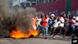 Demonstrators run away during a protest to demand the resignation of President Jovenel Moise and an explanation of how Petro Caribe funds have been used by the current and past administrations, in Port-au-Prince, Haiti, Feb. 9, 2019.