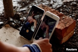 FILE - Shi Shenwei sets up his phones to record a high bar routine at the construction site of a Buddhist temple in the village of Huangshan, in Fujian Province, China, on September 28, 2016.