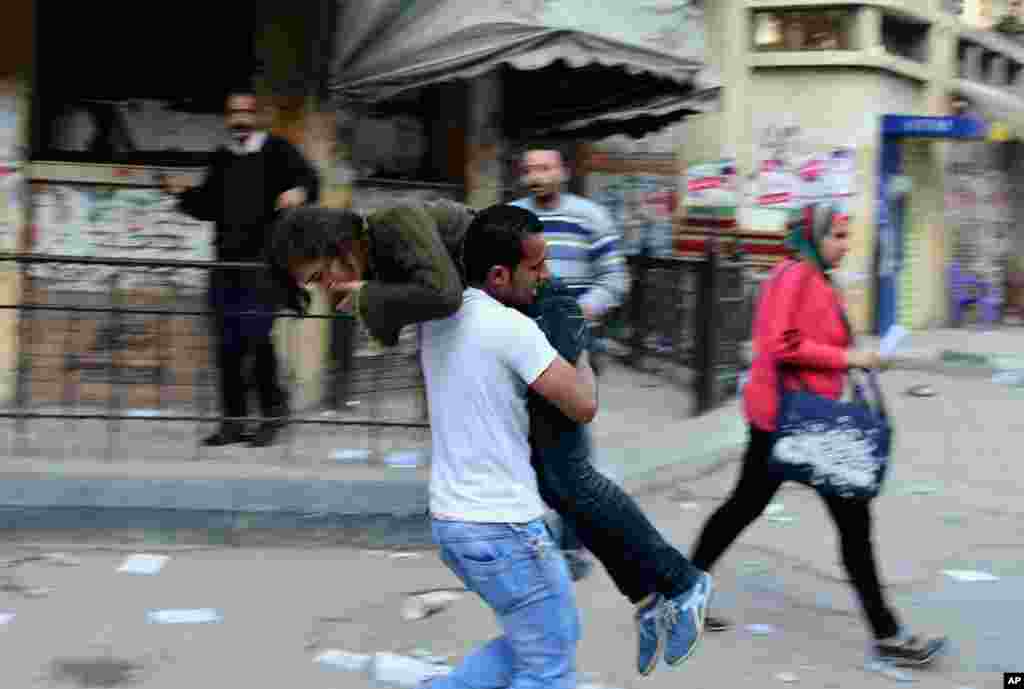 An Alexandria University student carries another student out of the school after she was injured during clashes between student protesters and the Egyptian security forces in Alexandria, March 26, 2014.