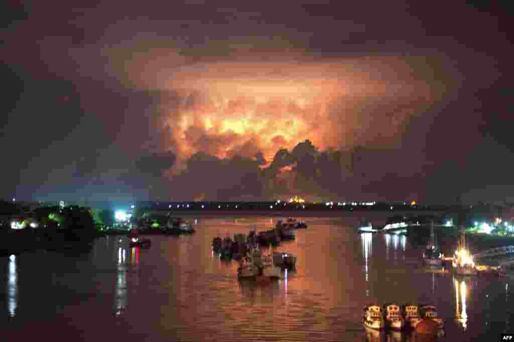 A storm lights up the sky above the Yangon river, Burma. Authorities began moving people into emergency shelters in Rakhaine state as a cyclone threatened to batter a violence-wracked region home to tens of thousands of internal refugees.