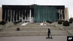 Municipal workers cover the burnt city hall building for repairs in Almaty, Kazakhstan, Jan. 13, 2022, following anti-government protests earlier this month that have since been quelled.