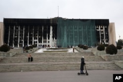 FILE - Municipal workers cover the burnt city hall building for repairs in Almaty, Kazakhstan, Jan. 13, 2022, following anti-government protests that have since been quelled.