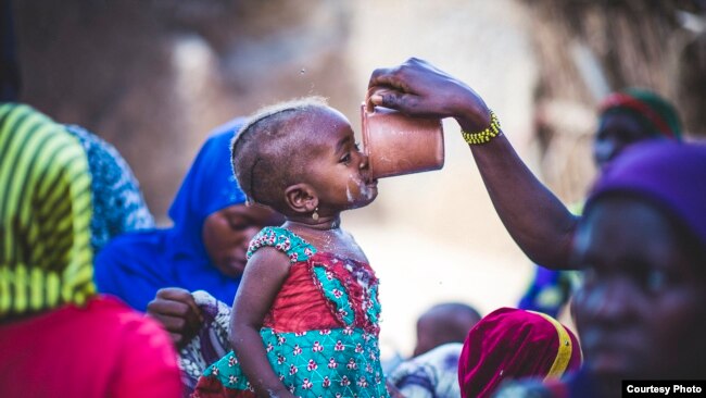 FILE - A toddler samples millet porridge after a cooking demonstration in Zinder, Niger, where a Mercy Corps program helps people grow and sell more nutritous food. The international relief group is a USAID partner. (Sean Sheridan photo courtesy of Mercy Corps)