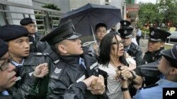 A protester scuffles with police officers who were trying to stop a fellow demonstrator from throwing a bag of tofu during a protest to support Chinese dissident Tan Zuoren at the Chinese government's liaison office in Hong Kong, 9 June 2010.