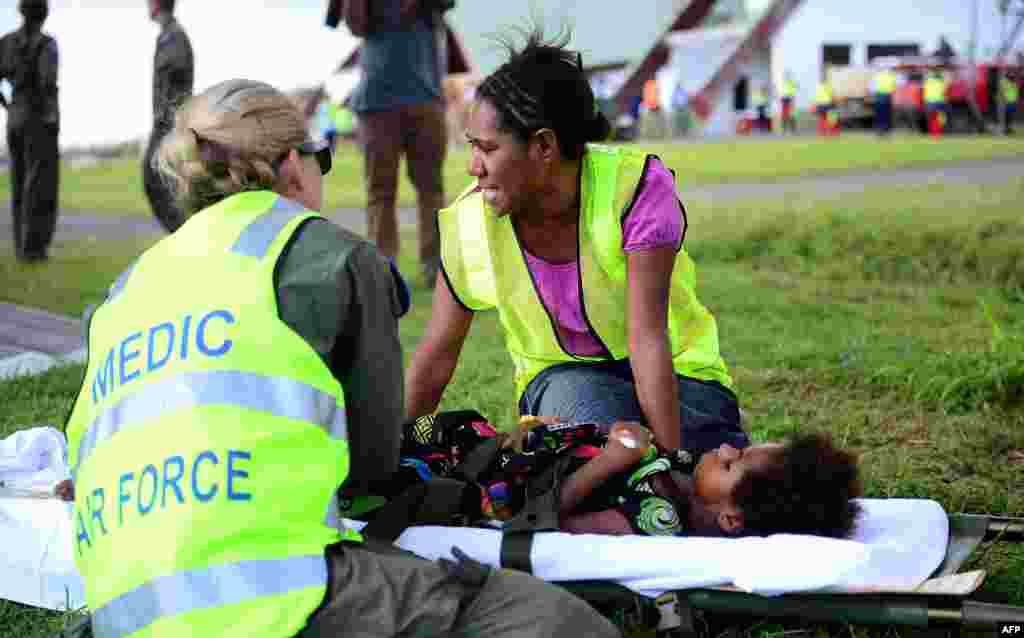 Australian doctors helping in the aftermath of Cyclone Pam give medical aid to a young girl on the Vanuatu island of Tanna, March 18, 2015. 