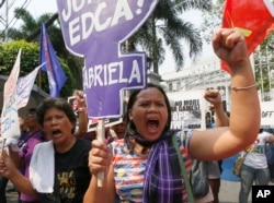 Protesters hold signs denouncing the Enhanced Defense Cooperation Agreement (EDCA) during a protest outside the Supreme Court in Manila on Jan. 12, 2016.