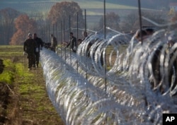 Slovenian soldiers erect a razor-wired fence on the Croatian border in Gibina, Slovenia, Nov. 11, 2015. The government aims to prevent the uncontrolled entry of more migrants in the already-overwhelmed alpine state.