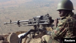 A Cameroonian soldier guards at an observation post on a hill in the Mandara Mountain chain in Mabass overlooking Nigeria, northern Cameroon, Feb. 16, 2015. 