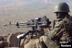 FILE - A Cameroonian soldier guards at an observation post on a hill in the Mandara Mountain chain in Mabass overlooking Nigeria, northern Cameroon, Feb. 16, 2015.