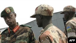 Le ministre de la Défense et ex-chef d'état-major de l'armée rwandaise, James Kabarebe, à gauche, inspecte à Kigali des troupes rwandaises faisant partie de la force de l'Union africaine, 17 juillet 2005.