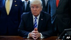 President Donald Trump pauses in the Oval Office of the White House in Washington, March 24, 2017, where it was announced the approval of a permit to build the Keystone XL pipeline, clearing the way for the $8 billion project, March 24, 2017.