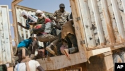 Des migrants montent dans un camion à destination de l'Algérie, au poste-frontière Assamaka, au Niger, le 3 juin 2018.