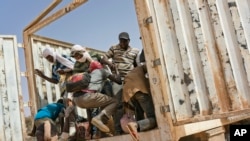 Migrants climb into a truck to head north into Algeria at the Assamaka border post in northern Niger on June 3, 2018.