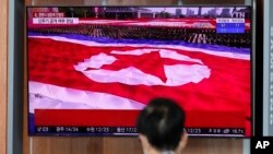 FILE - Footage of a parade in Pyongyang featuring a giant North Korean flag is seen at a TV screen during a news program reporting on North Korea, at the Seoul Railway Station, in Seoul, South Korea, Oct. 10, 2020. 